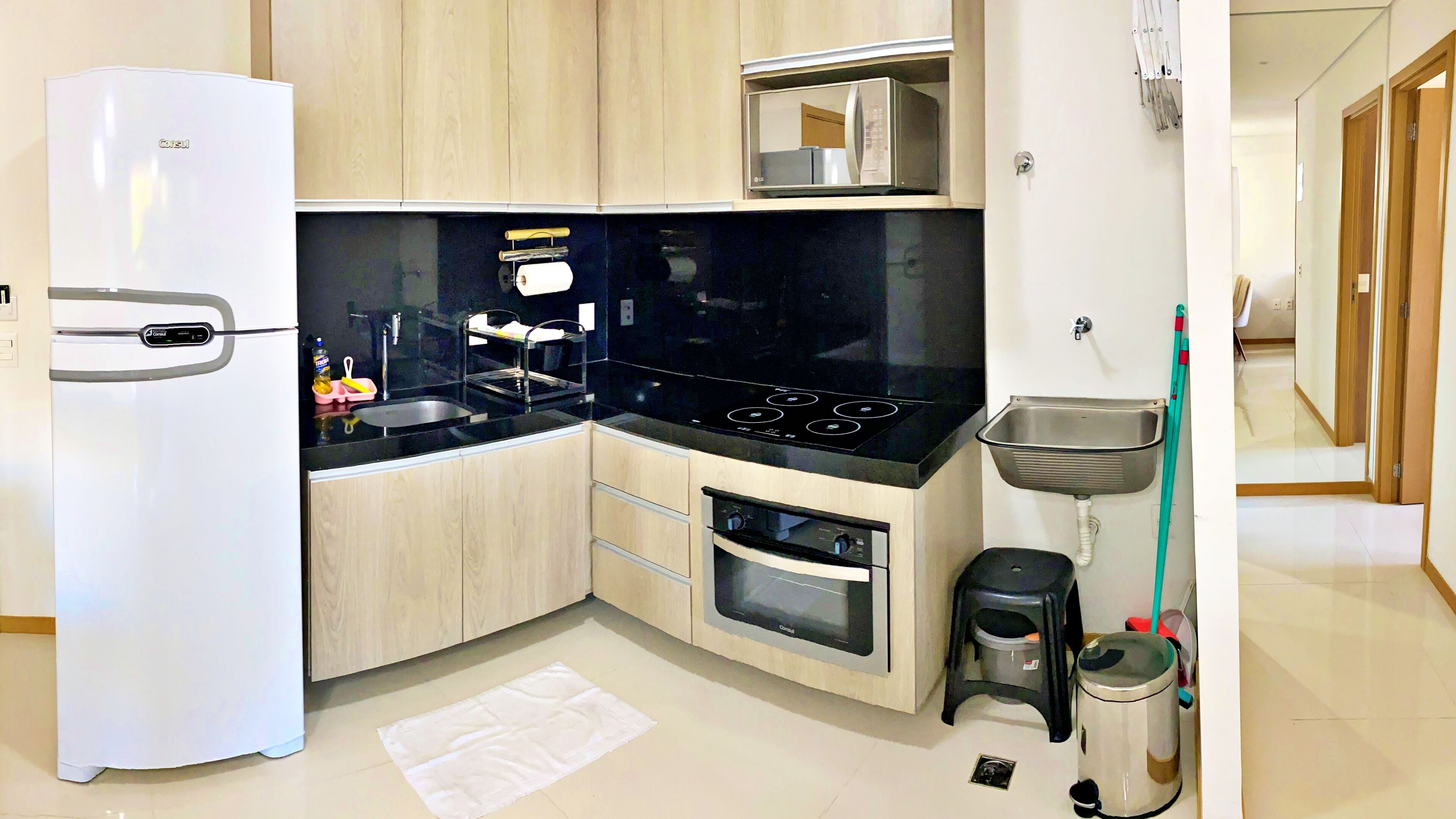 A modern kitchen with a refrigerator, stove, microwave, and oven.