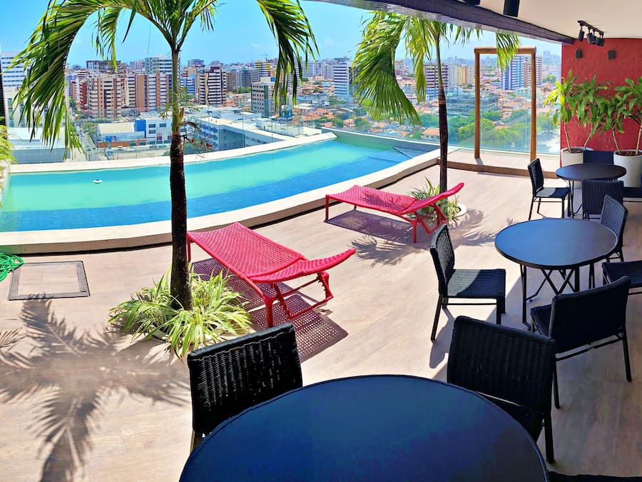 Una piscina techada, sombrillas, sillones reclinables de piscina