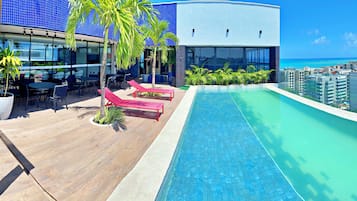 Una piscina cubierta, sombrillas, tumbonas