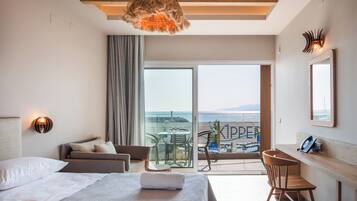 Habitación de hotel moderna con cama, escritorio y balcón con vistas al mar.