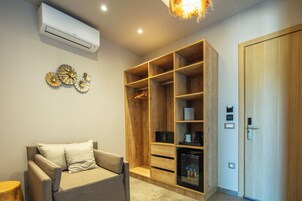 A modern room with a built-in wardrobe, a sofa, and a wall-mounted air conditioner.