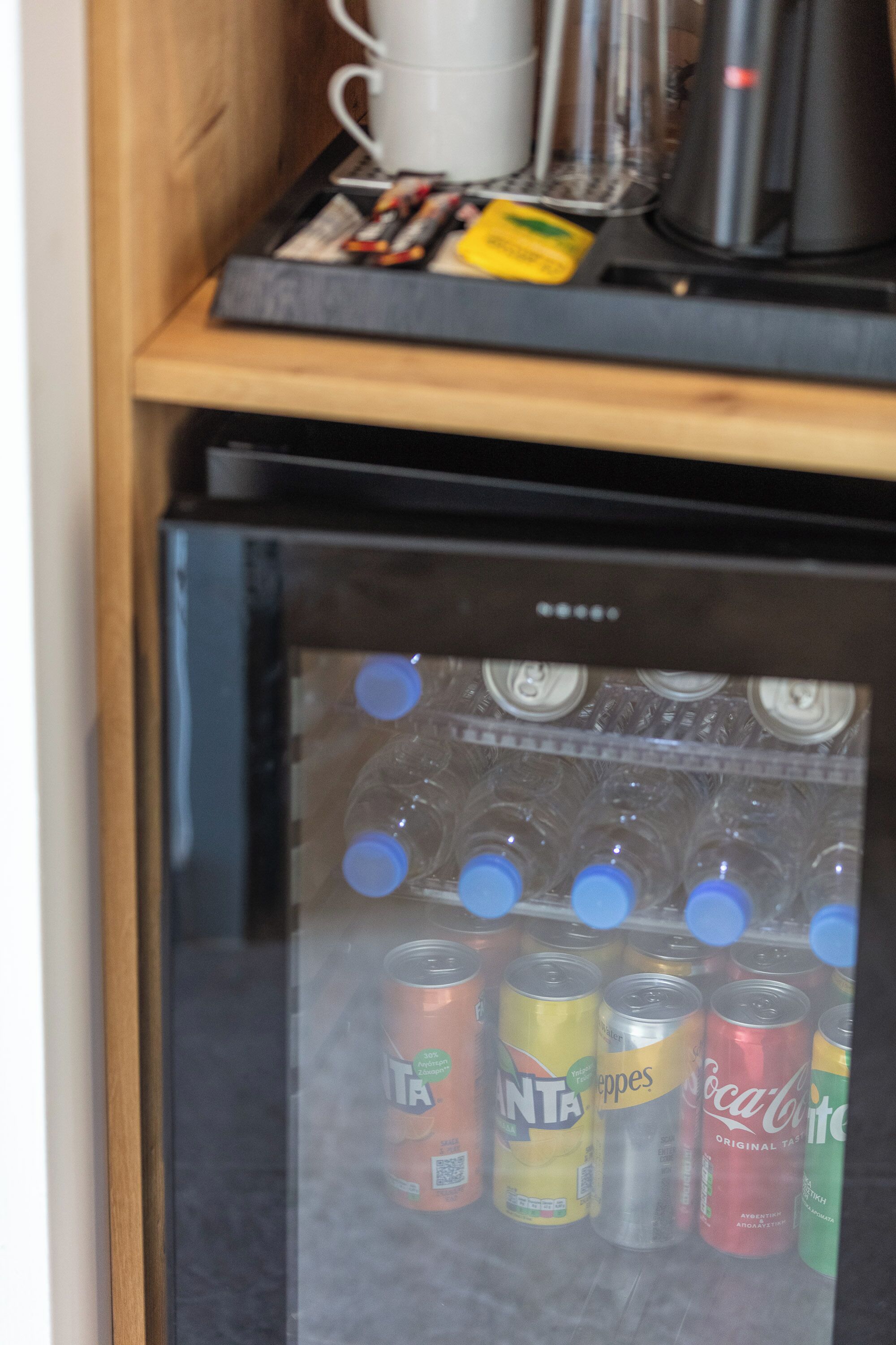 A refrigerator stocked with various beverages, including cans of soda and water.