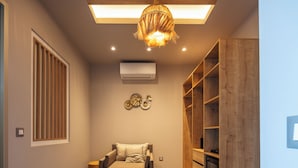 Una habitación moderna con sofá, estanterías de madera y una lámpara en el techo.