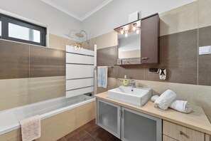 A modern bathroom with a bathtub, a sink, and a shower area. - Villa Bella - Mountain views & Outdoor living (Machico)