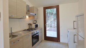 A modern kitchen with a sink, stove, microwave, oven, and cabinets.