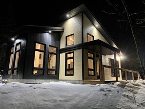 Stunning two-story house with a gabled roof and large windows on the upper level.