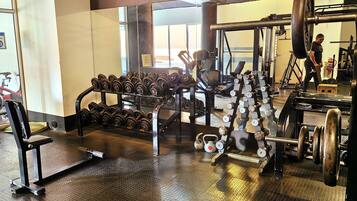 A gym with various weightlifting equipment, including dumbbells and barbells.