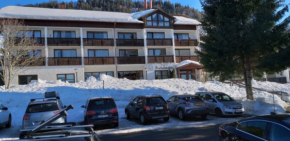 A multi-story hotel with a restaurant on the ground floor, surrounded by snow.