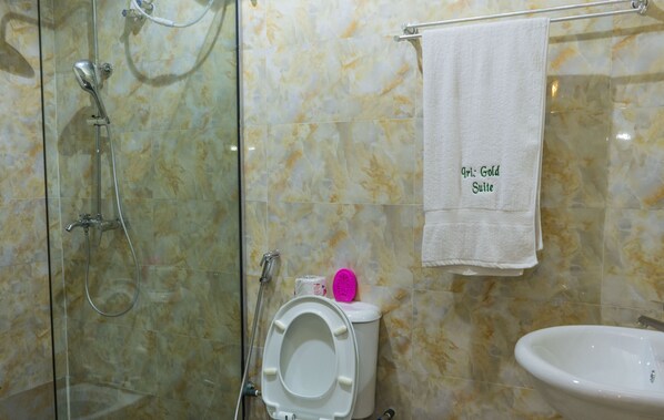 A bathroom with a shower, toilet, and sink.