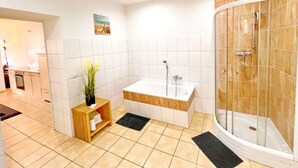 Une salle de bain moderne équipée d’une douche, d’une baignoire et d’un lavabo.