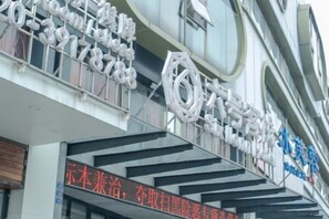 A hotel with a modern facade, large signage, and a prominent entrance. - Guangzhou No.6 Inn (Panyu District Ha Street Branch) (Guangzhou)