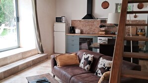 A modern living room with a brown leather sofa, a wooden coffee table, and a staircase.