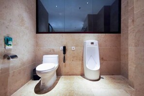 A modern bathroom with a toilet, urinal, and a mirror. - Taoran Zhongzhou Guobin Hotel (Zhong County)