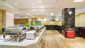 Un hall d’hôtel moderne avec un long comptoir agrémenté d’un grill et d’une horloge placée sur un pilier.