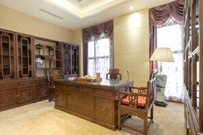 A traditional room with a wooden desk, shelves, and a chair.