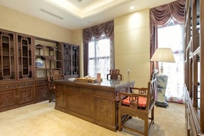 A traditional room with a wooden desk, a chair, and a cabinet.