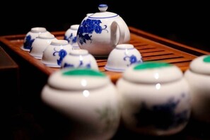 Un juego de teteras y tazas de cerámica blanca y azul dispuesto en una bandeja.