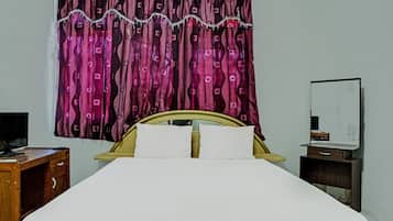 Un letto con biancheria bianca, una testiera in legno e una tenda decorata.