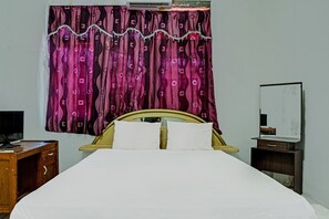 A bed with white bedding, a wooden headboard, and a curtain with a pattern. - Hotel O Kost Axcel (Banjarmasin)