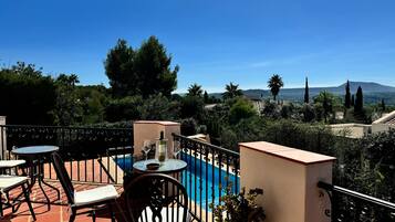 Relax on the terrace with a pool, surrounded by lush greenery and breathtaking views of the landscape.