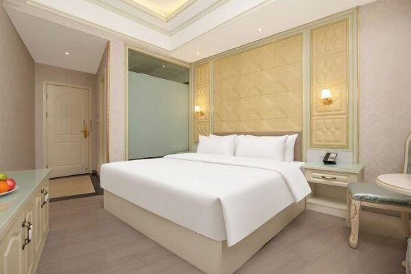 A hotel room with a large bed, bedside tables, a chair, and a mirror. - Huiqian Hotel (Dream Store) (Zhaotong)