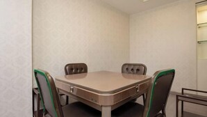 Une salle de conférence avec une table rectangulaire, quatre chaises et un luminaire au plafond.
