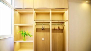 Un placard en bois avec plusieurs étagères et un espace pour suspendre les vêtements.
