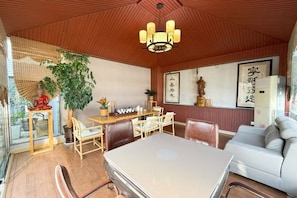 Een traditionele Japanse kamer met tatami vloerbedekking, een lage tafel en een bank.