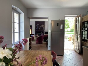 Enjoy cooking and dining in this well-lit kitchen with a central island, oven, and refrigerator.