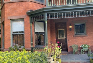 A brick building with a porch, a door, and a window with shutters. - Stunning historic Victorian house in Newburgh (Newburgh)
