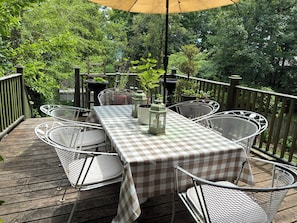 An outdoor patio with a checkered tablecloth, metal chairs, potted plants, and a lantern. - Stunning historic Victorian house in Newburgh (Newburgh)