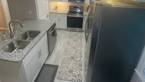 A compact kitchen with a sink, stove, microwave, and refrigerator. - Luxurious and peaceful (Topeka)