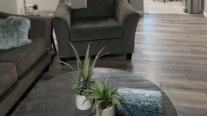 A modern living room with a gray sofa, a coffee table with plants, and a ceiling fan. - Luxurious and peaceful (Topeka)