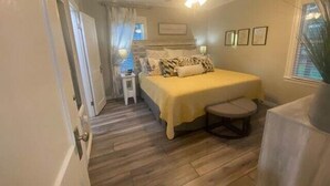 A bedroom with a bed, a nightstand, a chair, and a ceiling fan. - Luxurious and peaceful (Topeka)