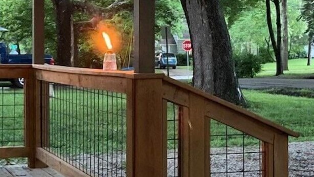 A wooden deck with a railing, a stop sign in the background, and trees. - Luxurious and peaceful (Topeka)