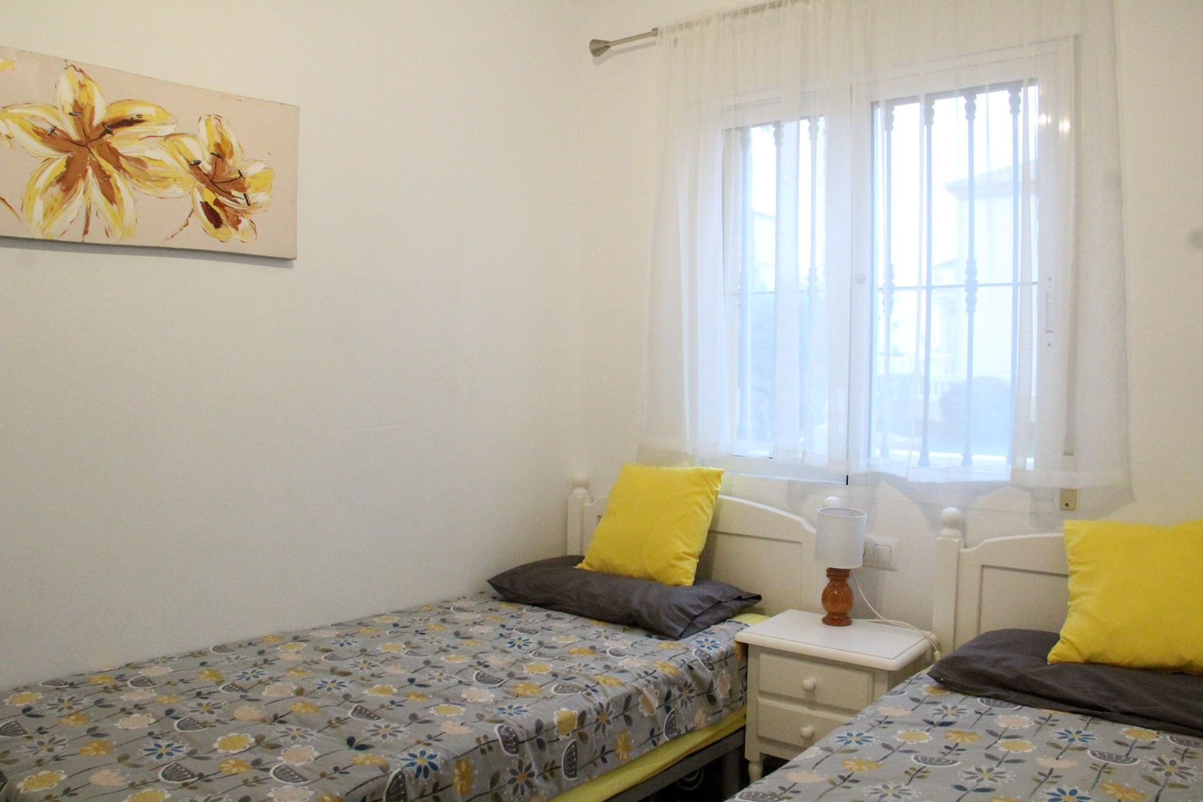 Une chambre avec deux lits simples, chacun étant équipé d’un oreiller et d’une table de chevet.