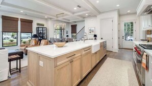 A spacious kitchen with a large island, wooden cabinets, and a modern design.