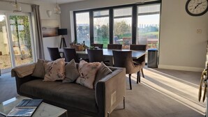 Un salon comprenant un canapé, une table basse et un coin repas avec des chaises et une table.