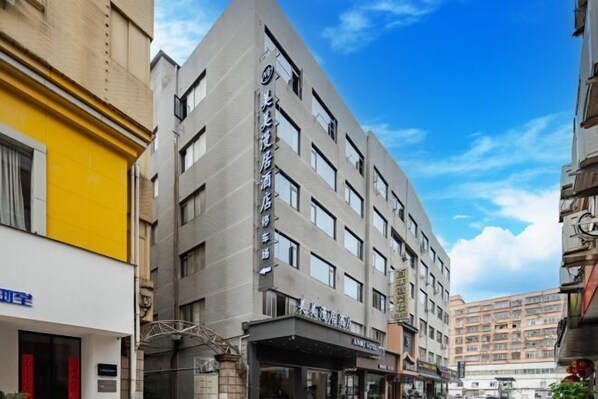 A multi-story hotel with a modern design, featuring a prominent entrance and a visible signboard.