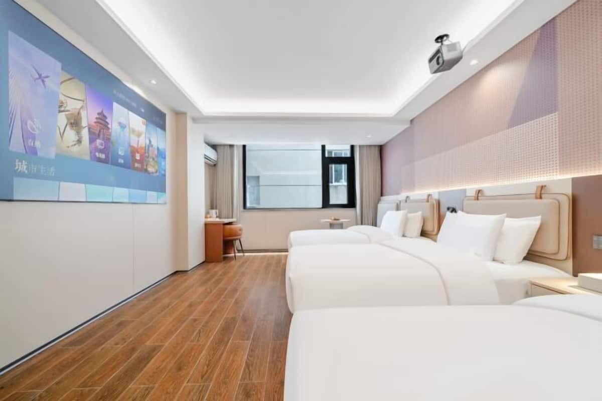 Une chambre d’hôtel avec un grand lit, une petite table, une chaise, un téléviseur et une fenêtre.