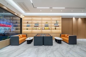 A modern lounge area with seating and a wall display. - Meimei Manju Hotel (Liushi Branch, Yueqing, Wenzhou) (Yueqing)