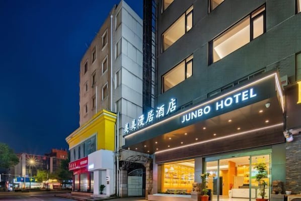 Un hotel con un letrero llamativo, una fachada moderna y grandes ventanales.