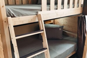 A bunk bed with a ladder, a pillow, and a curtain. - Beret B&B (Tengchong)