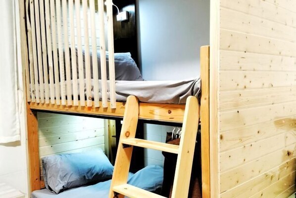 A bunk bed with a wooden ladder, a window with vertical blinds, and a wooden wall. - Beret B&B (Tengchong)