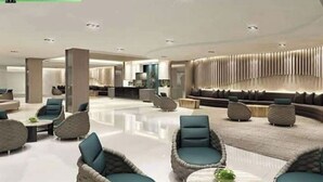 A spacious lobby with modern seating areas, a reception desk, and a decorative wall. - Serenity Cove MOA Cozy condo unit amenity view. (Pasay)