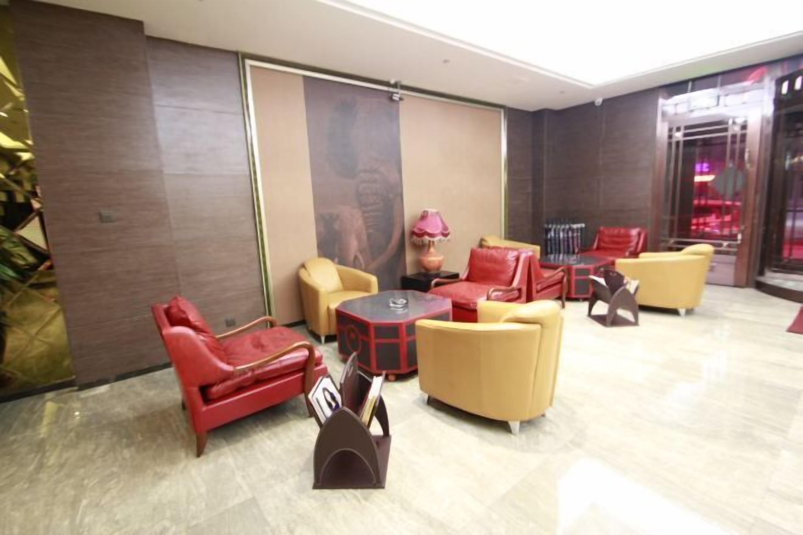 A lobby with red and yellow sofas, a small table, and a decorative lamp.