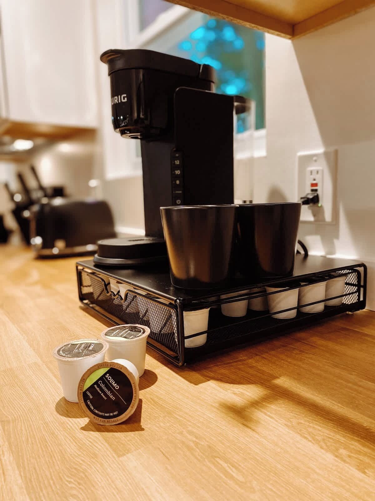 A coffee machine on a kitchen counter with a coffee bean container and a coffee grinder.
