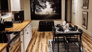 Eine moderne Küche mit Essbereich, Holzboden und einem großen Gemälde an der Wand.