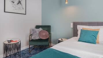 A neatly arranged bedroom with a bed, a chair, a small table, and a wall-mounted air conditioner.