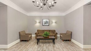 A living room with a brown sofa set, a wooden coffee table, and a chandelier. - Quality Inn & Suites Santee I-95 (Santee)